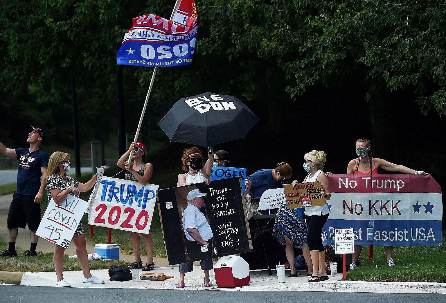 Protesters and supporters of US President Donald Trump sending their respective messages outside the Trump National Golf Club in Sterling, Virginia, on Sunday.