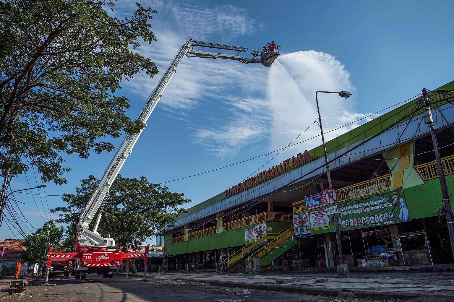 Indonesian firefighters spraying disinfectant in Surabaya yesterday as a precautionary measure against the spread of Covid-19.