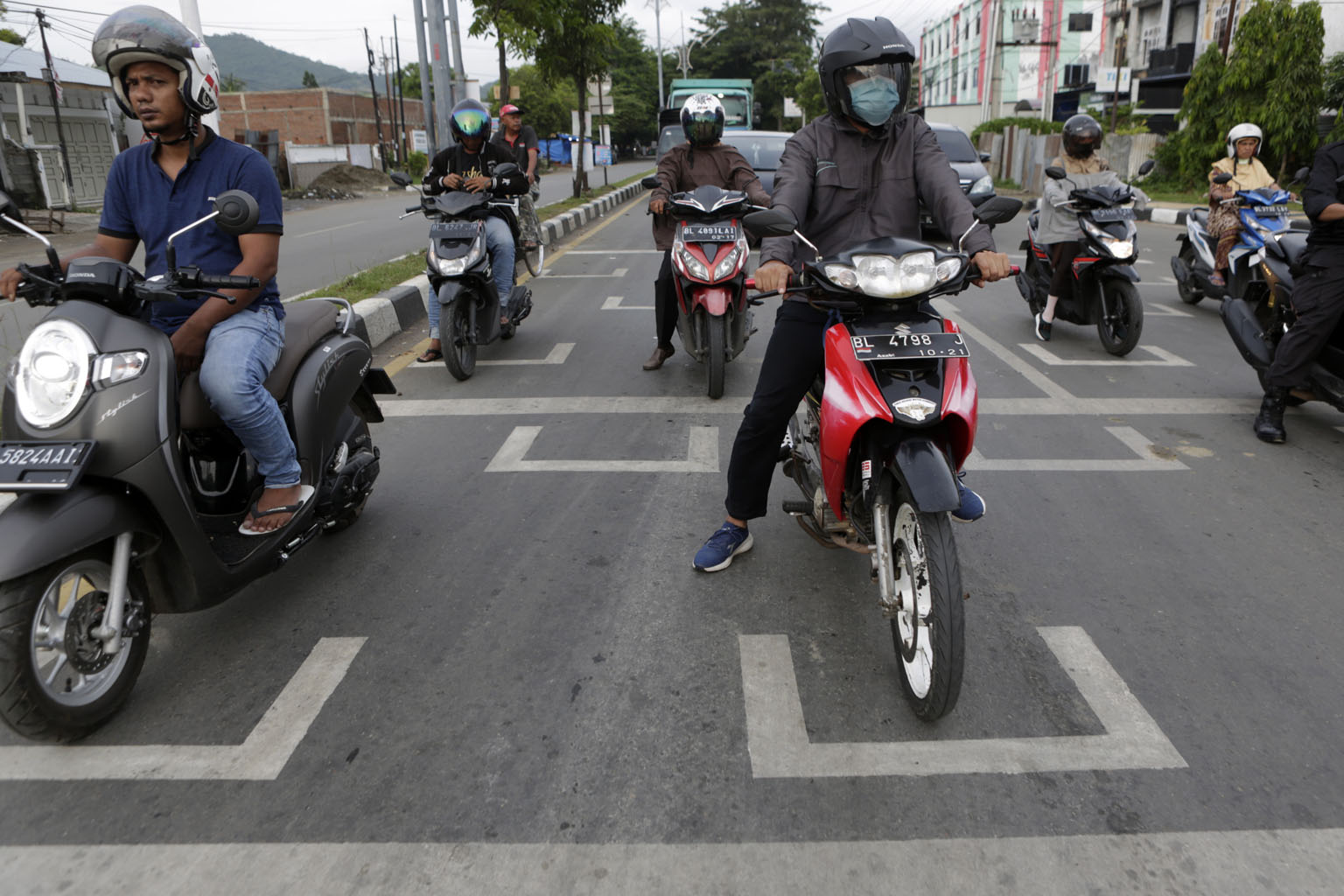 Motorists in Indonesia's Banda Aceh stopping in designated safe distancing spots at a traffic light as part of measures to curb the spread of Covid-19. Indonesia has been easing restrictive measures under a "new normal" but has seen record cases and