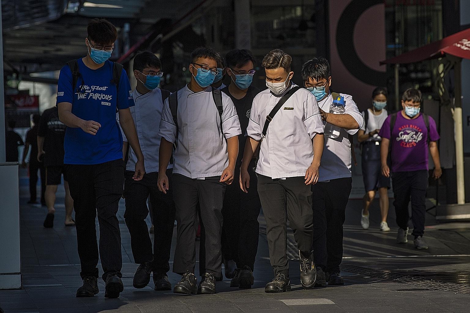 People in Kuala Lumpur wearing masks as they walk to work. Malaysia yesterday recorded four coronavirus recoveries and 16 new infections, including eight imported cases.