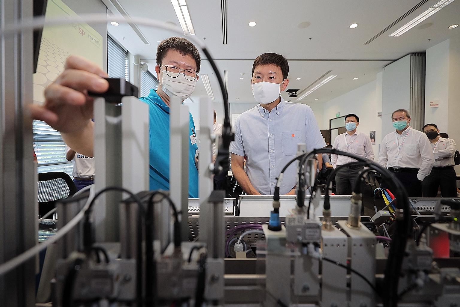 Senior Minister of State for Education as well as Trade and Industry Chee Hong Tat (right) yesterday observing trainee Goh Chye Lim show what he learnt at his training session conducted at the Bosch South-east Asia headquarters in Bishan. The German 