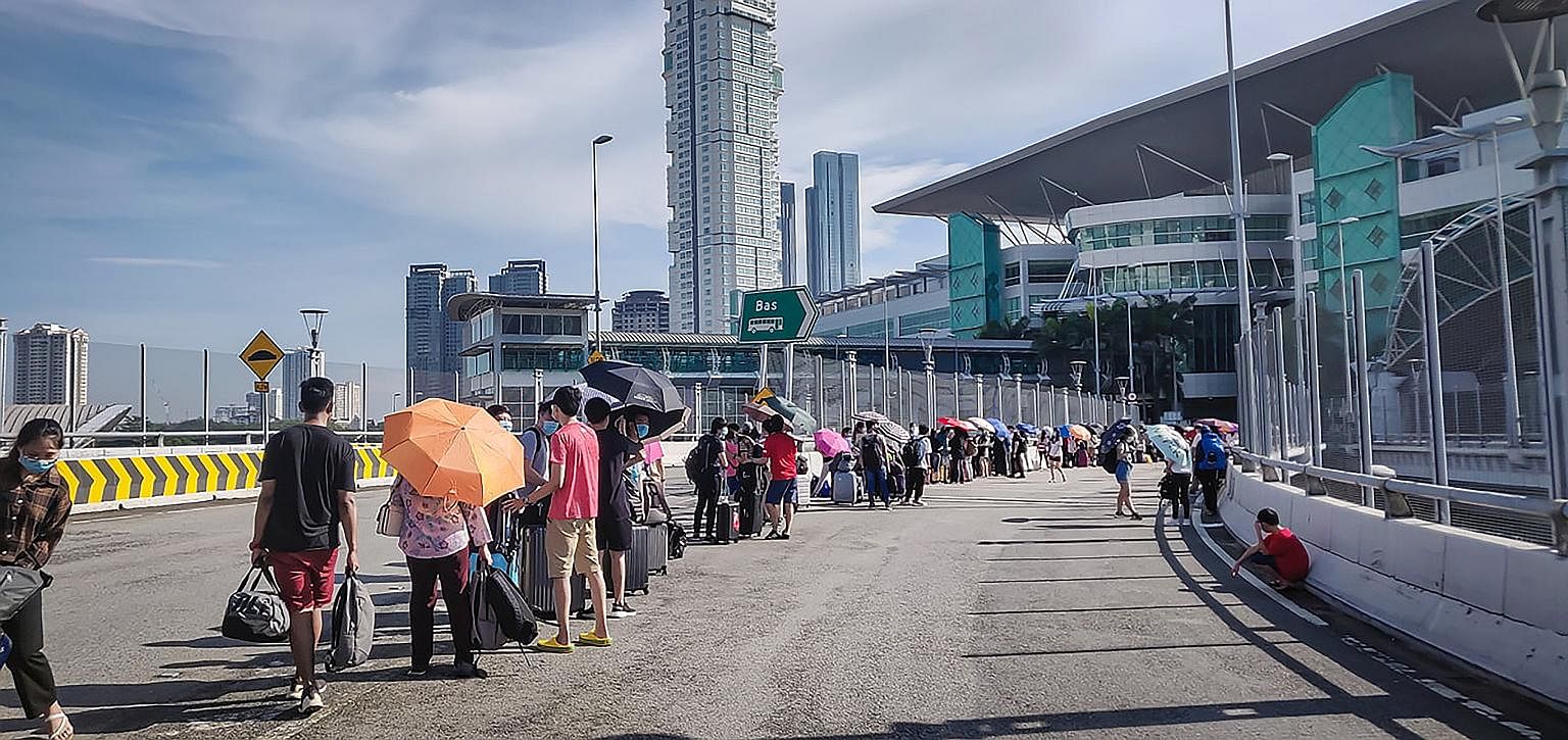 Malaysian workers in Singapore returned to Johor Baru in droves yesterday, ahead of a new rule that will see those returning to Malaysia serve 14 days in quarantine at designated facilities and pay for it. As a result, snaking queues (left and above)