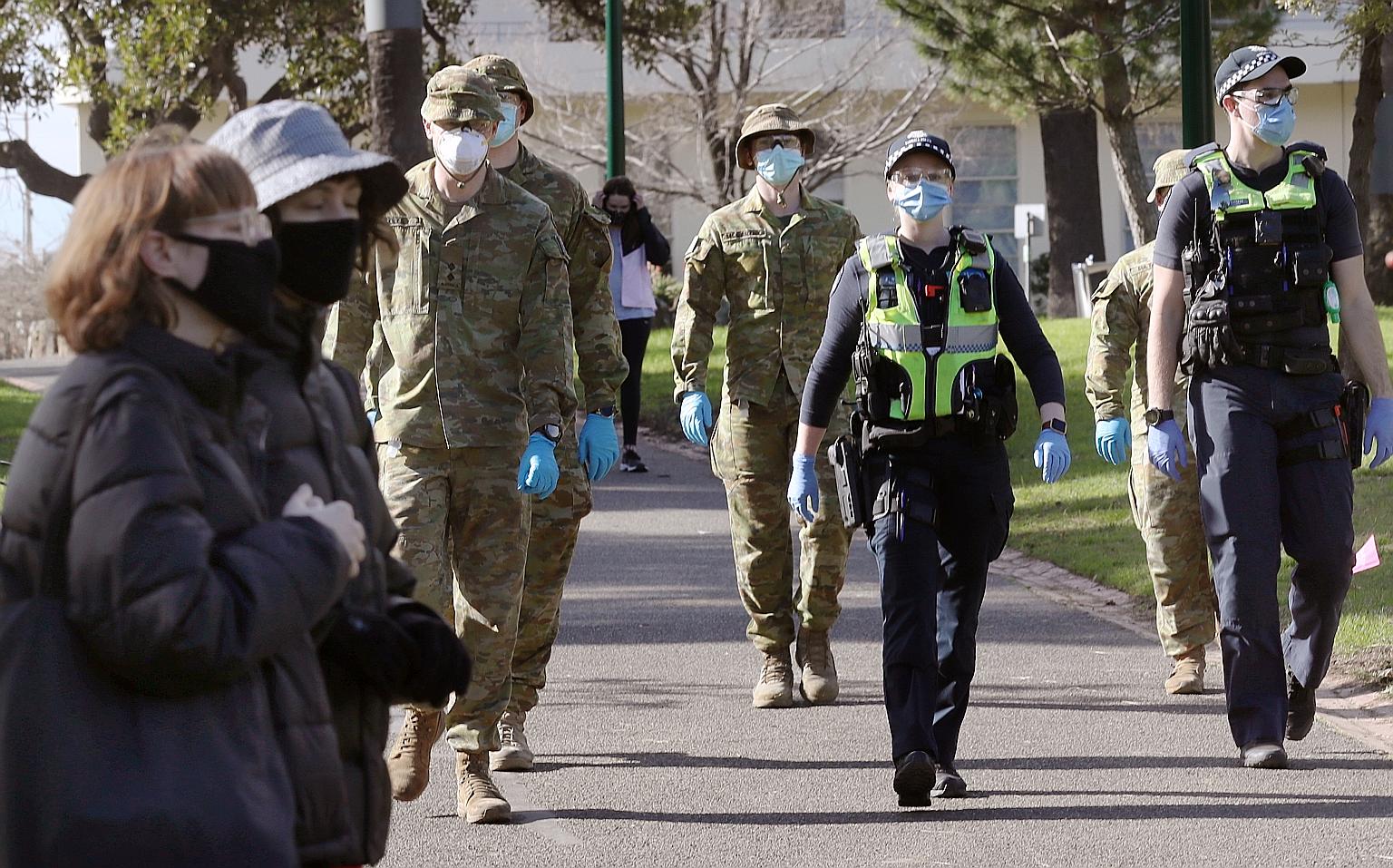 Australian Defence Force personnel and Victorian police officers patrolling Fitzroy Gardens in Melbourne yesterday amid a resurgence in Covid-19 cases. A six-week partial lockdown has been enforced in Melbourne.