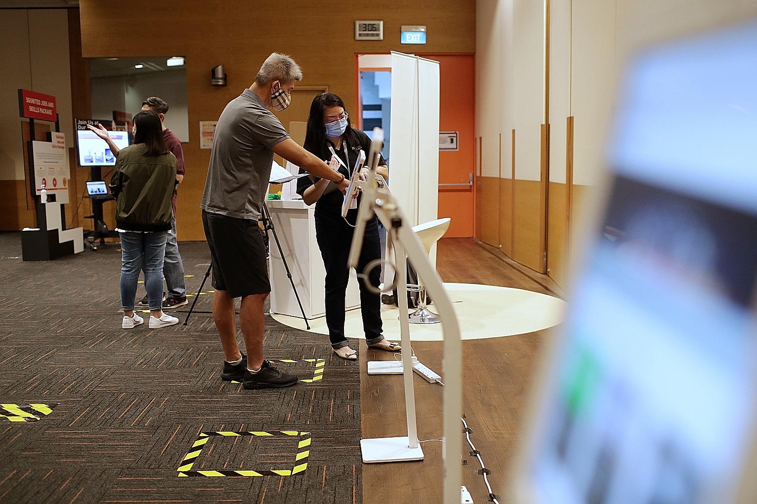 Mr Alex Ng (centre), who was retrenched from his IT sales role at a multinational corporation about a month ago, at a jobs and skills event at the Lifelong Learning Institute in Eunos yesterday. The 47-year-old said he was eyeing courses by Google an