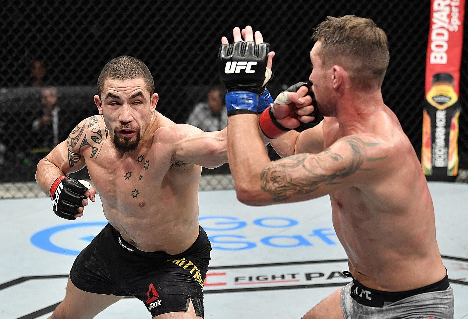 Robert Whittaker landing one of his 52 strikes on his English opponent Darren Till. They were fighting in an empty arena in the UAE.