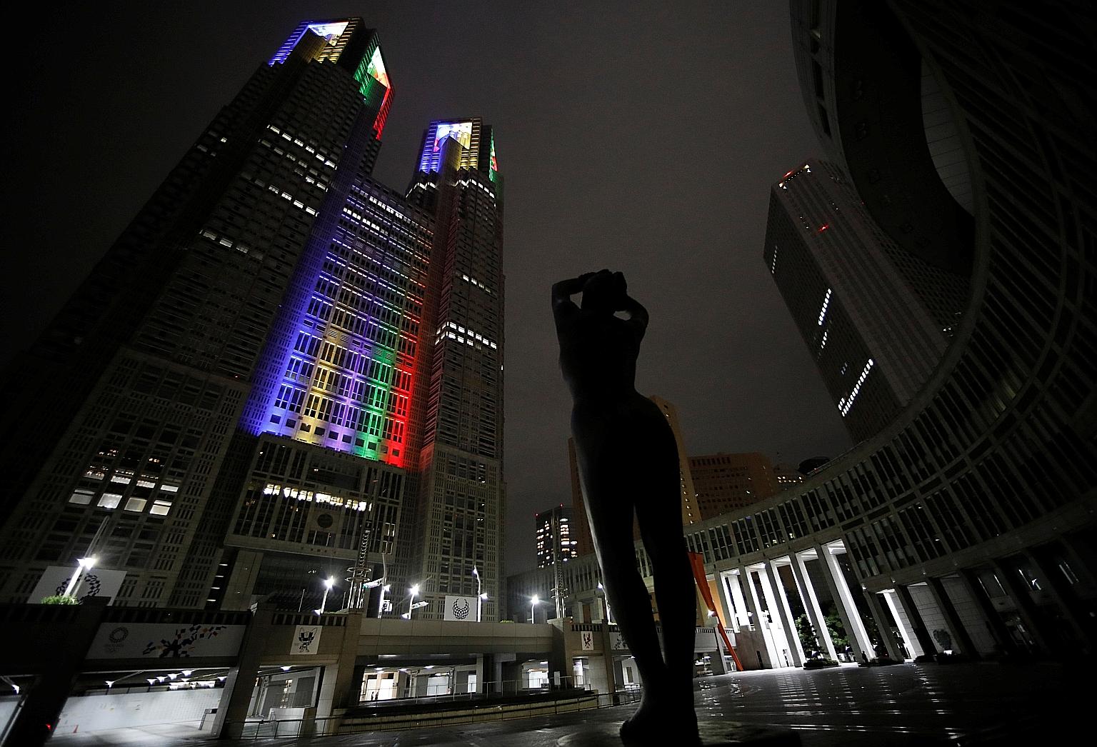 The Tokyo Metropolitan Government Building in Shinjuku is lit up in Olympic colours a year to the day the postponed Games are slated to open next July. Australia's Olympic Committee president maintains a "gut feeling" that the Olympics will go ahead.