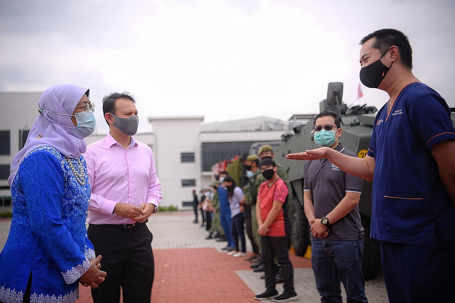President Halimah Yacob and Senior Minister of State for Defence Zaqy Mohamad speaking to Sengkang General Hospital surgeon Foo Fung Joon (right) and Singapore Land Authority senior manager Quek Boon Key during a National Day Parade mobile column reh