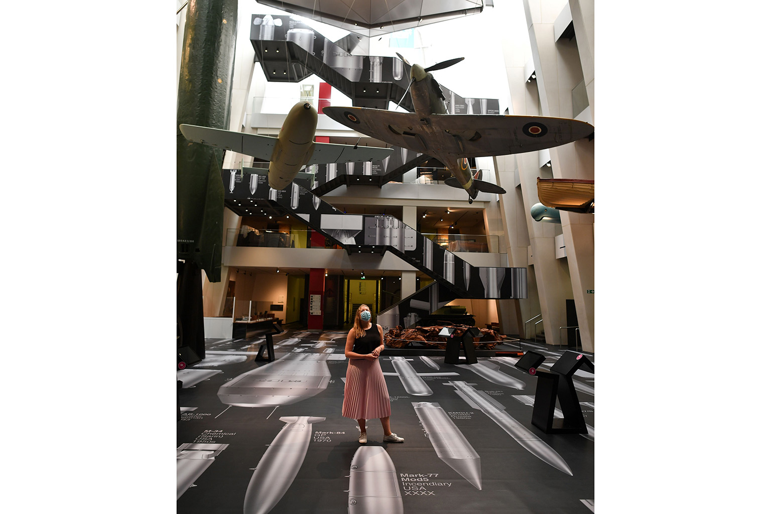 A visitor crossing a floor covered with to-scale images of bombs from World War I to the present day, during a photo call to promote History Of Bombs, an artwork by artist Ai Weiwei at the Imperial War Museum London yesterday. History Of Bombs is an