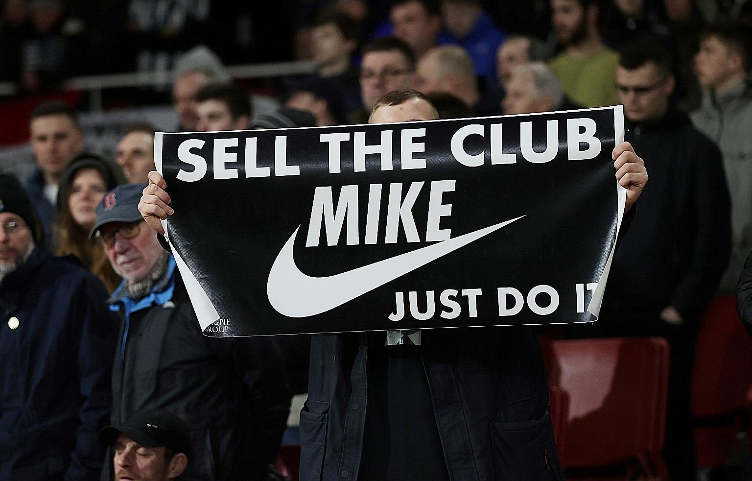 A fan displaying a banner referring to Newcastle owner Mike Ashley during the Magpies' match against Arsenal at the Emirates in February.