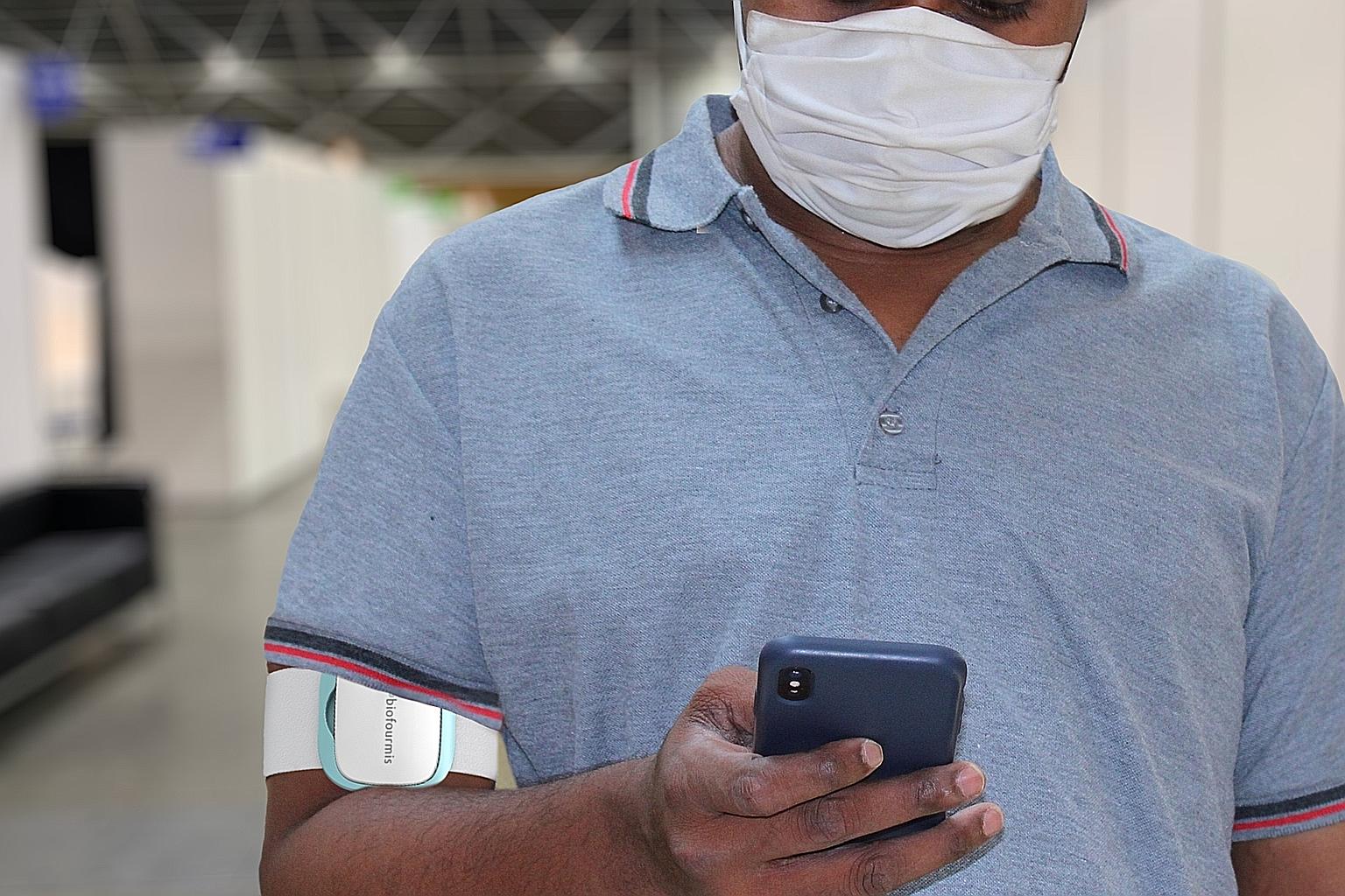 Patients can have their vital signs monitored round the clock, with a sensor device worn on their upper arm (left) and doctors can use the real-time data to detect any signs of deterioration early and intervene quickly (below). PHOTOS: BIOFOURMIS