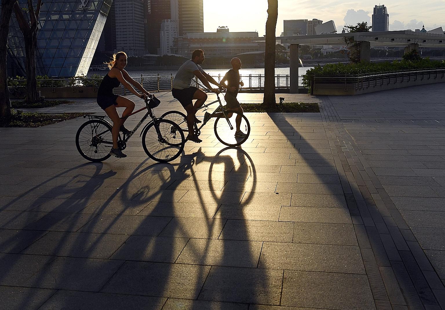 Cyclists and a jogger at the Marina Bay Waterfront Promenade in April. Exercise is more beneficial for those with a diet low in sugar and saturated fat.