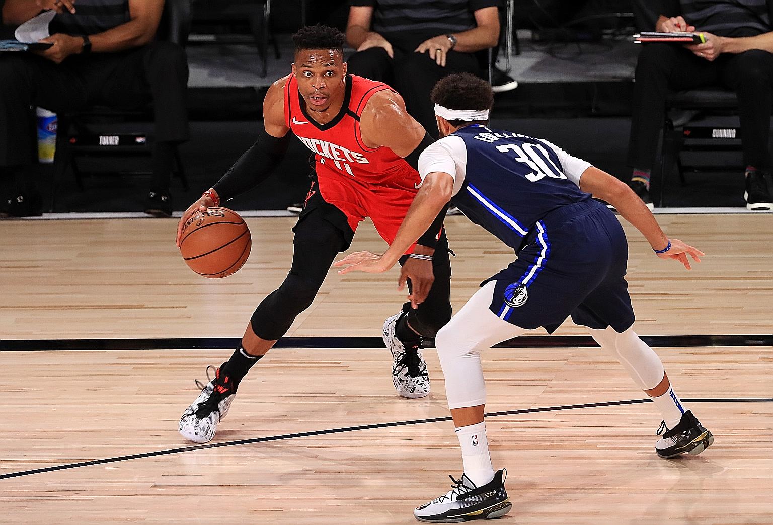 Houston Rockets' Russell Westbrook trying to dribble past Dallas Mavericks' Seth Curry in their match on Friday. Westbrook scored 31 points.