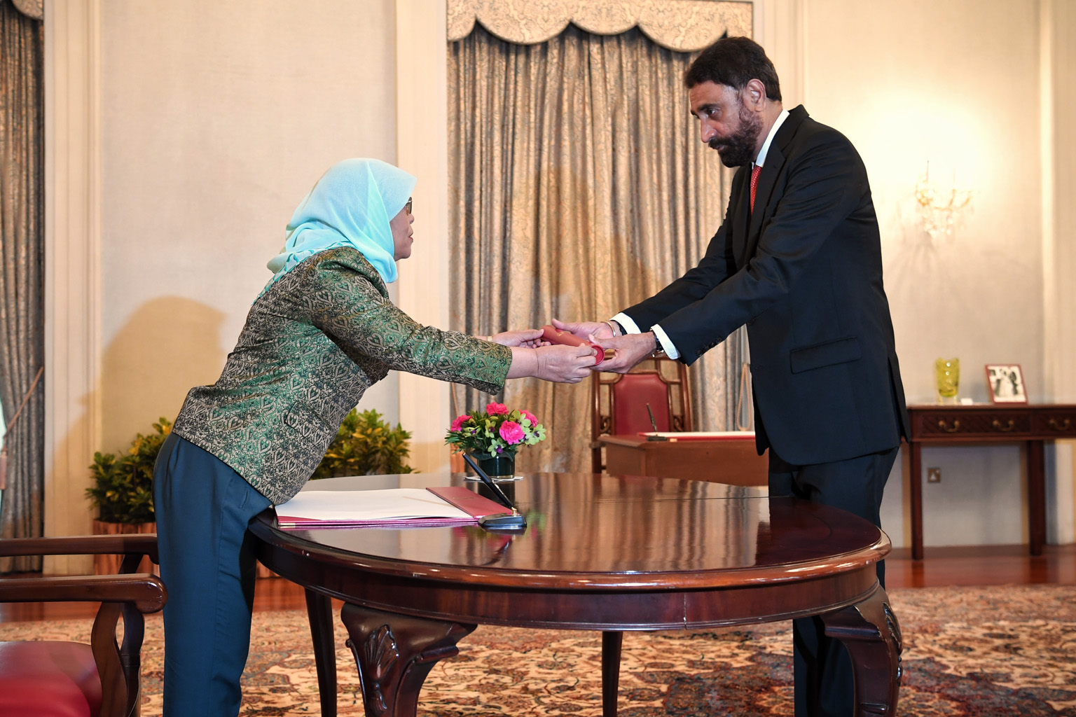President Halimah Yacob presenting the Instrument of Appointment to Justice Dedar Singh Gill at yesterday's swearing-in and appointment ceremony at the Istana.