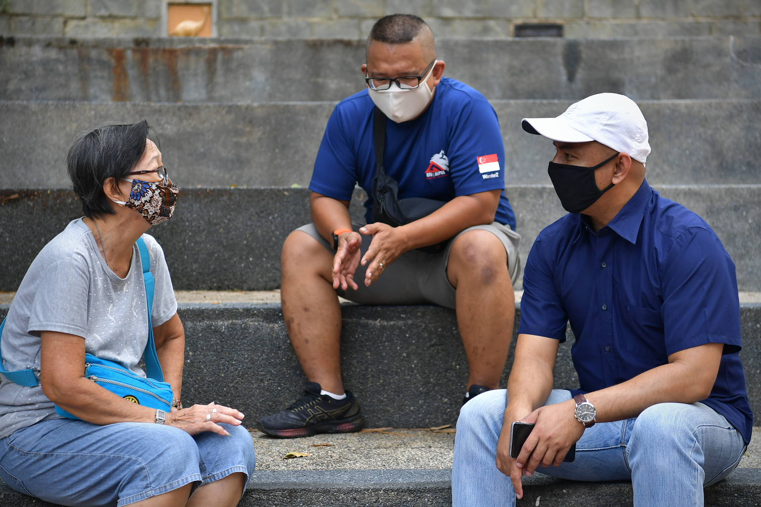 Volunteers from the Yellow Ribbon Community Project's Woodlands division Mohamad Ridzal Abdul Razak (centre) and Isam Sulong speaking to a project beneficiary. Supporters are spreading the Yellow Ribbon Project's message of redemption and hope throug