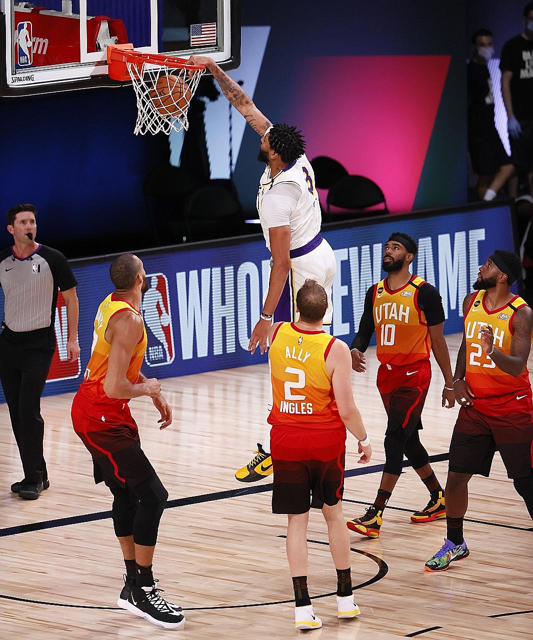 Los Angeles Lakers forward Anthony Davis dunks against Utah Jazz defenders during their NBA game at the ESPN Wide World of Sports Complex. Davis led with a game-high 42 points as the Lakers beat their rivals 116-108 to secure the top seeding.