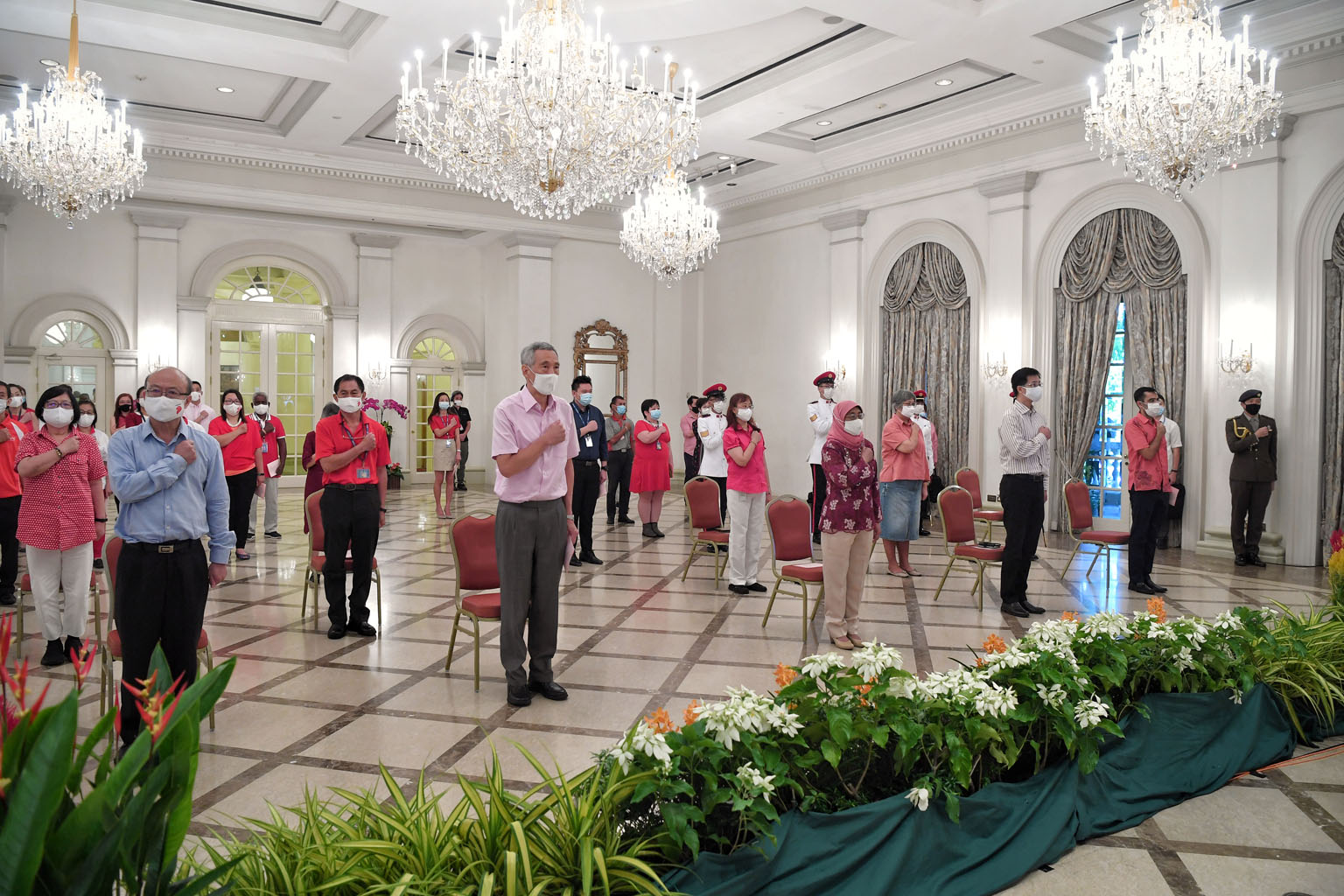 The National Day observance ceremony at the Istana yesterday was a smaller, quieter affair due to Covid-19. President Halimah Yacob and Prime Minister Lee Hsien Loong were joined by the Istana's and Prime Minister's Office staff, including (left) Cab