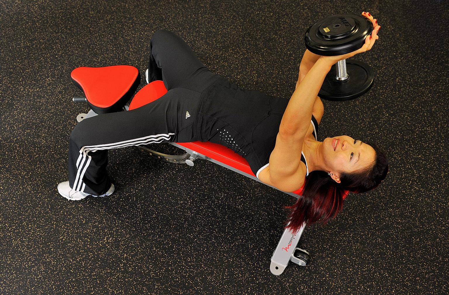 Joan Liew, director of boutique gym Fitness Factory, doing the dumb-bell pullover. This exercise works the chest, back, rear deltoids, triceps and abs.