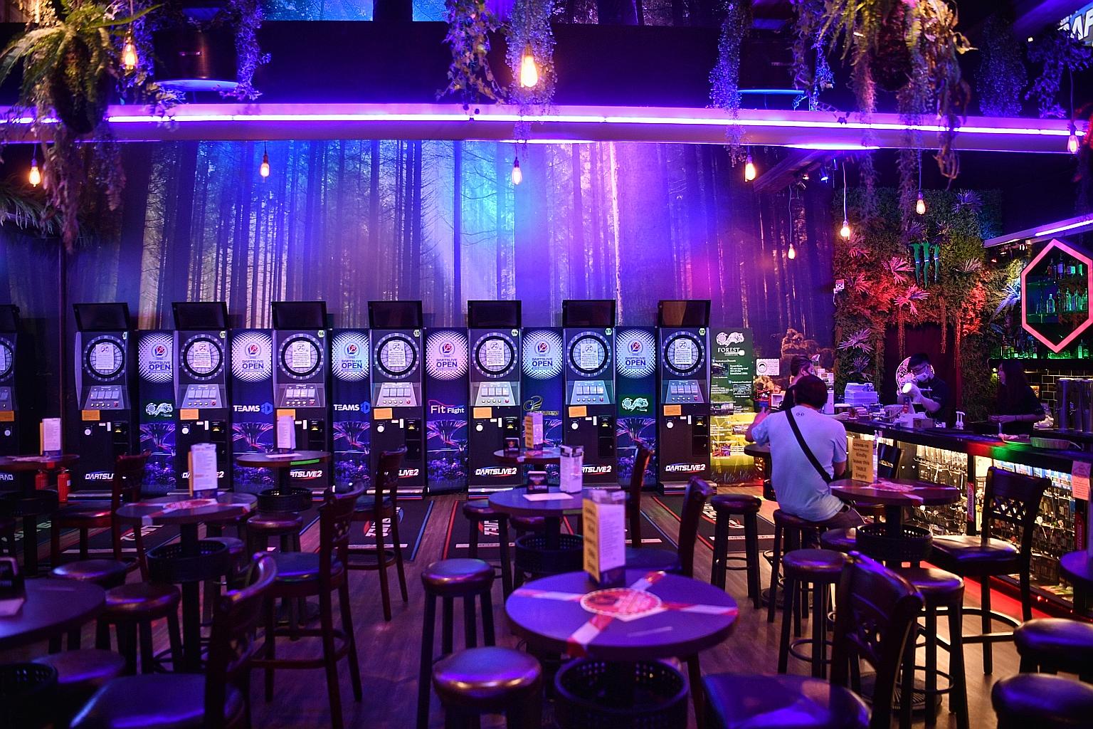 Forest Darts Cafe has reopened its Downtown East outlet but the approval process was onerous and costly, said co-owner Lena Sitoo. Few customers have returned as the darts and karaoke machines must remain powered down.