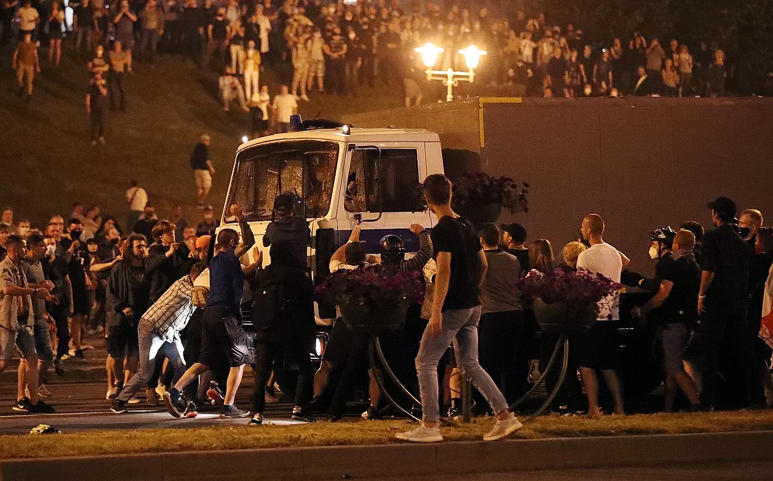 A police truck, carrying demonstrators, making its way through a crowd of protesters in Minsk on Sunday after polling stations closed following the Belarus presidential election. Thousands of people took to the streets in protest after President Alex