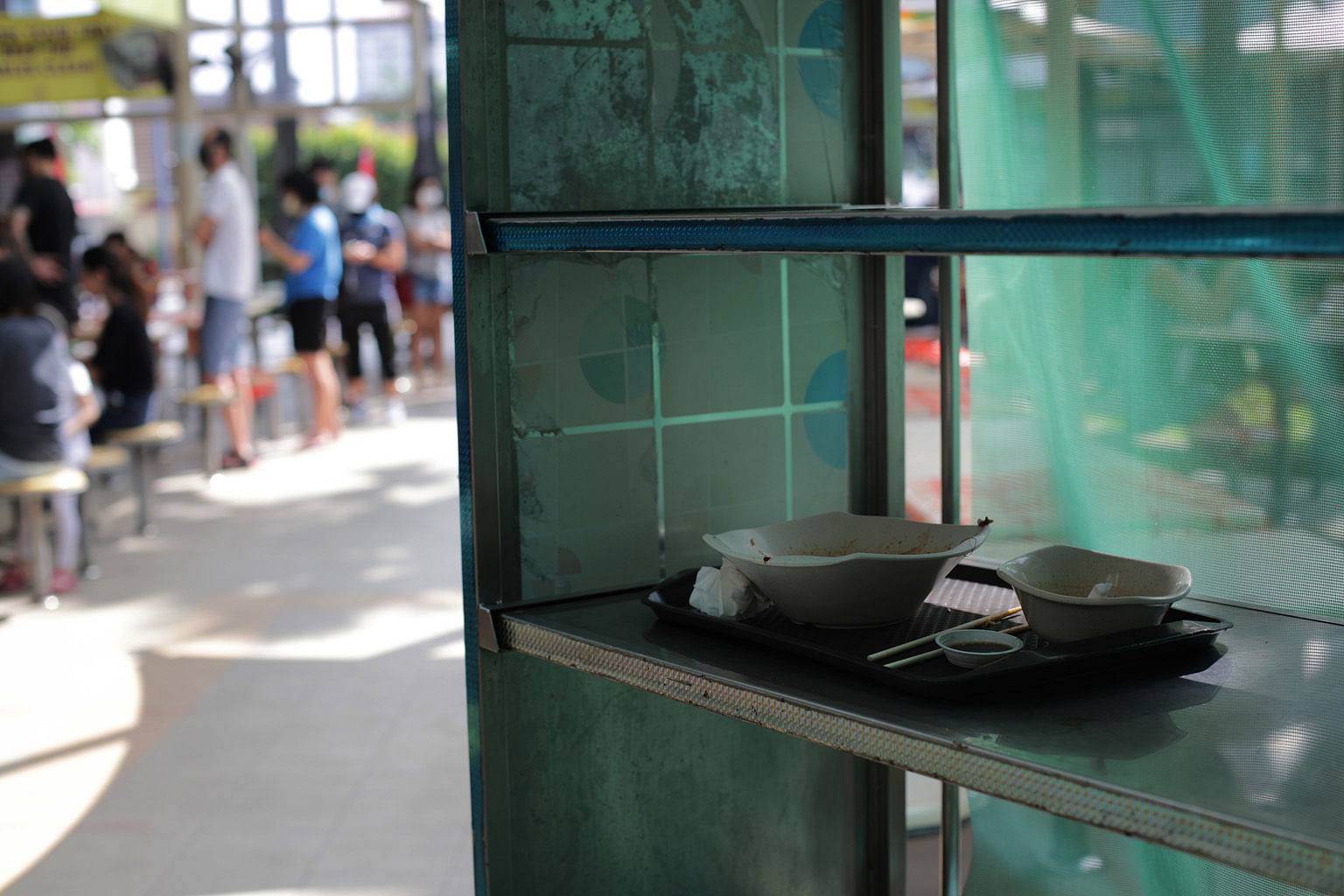 Used crockery and a tray left on a table at Teck Ghee market yesterday, when a Straits Times check found that on average, eight out of 10 diners did not follow the SG Clean task force's recommendations.