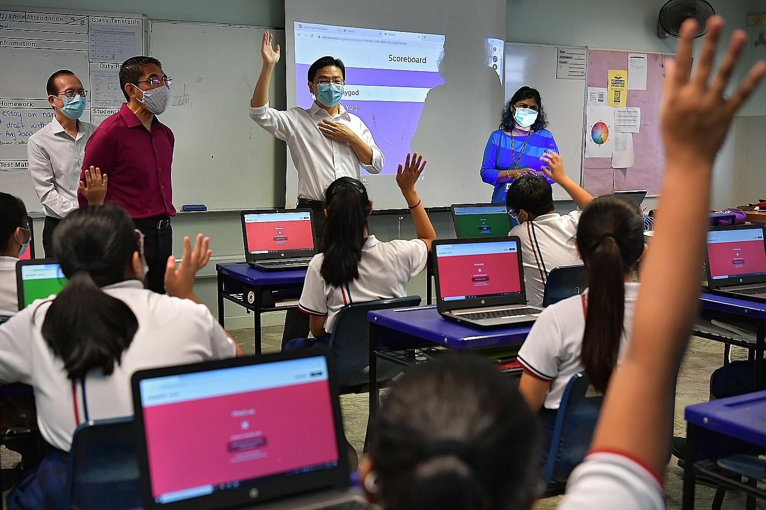 Education Minister Lawrence Wong (centre) and Second Minister for Education Maliki Osman (second from left) at Marsiling Secondary School yesterday. Mr Wong said making education a social leveller will involve ensuring schools "remain an uplifting fo