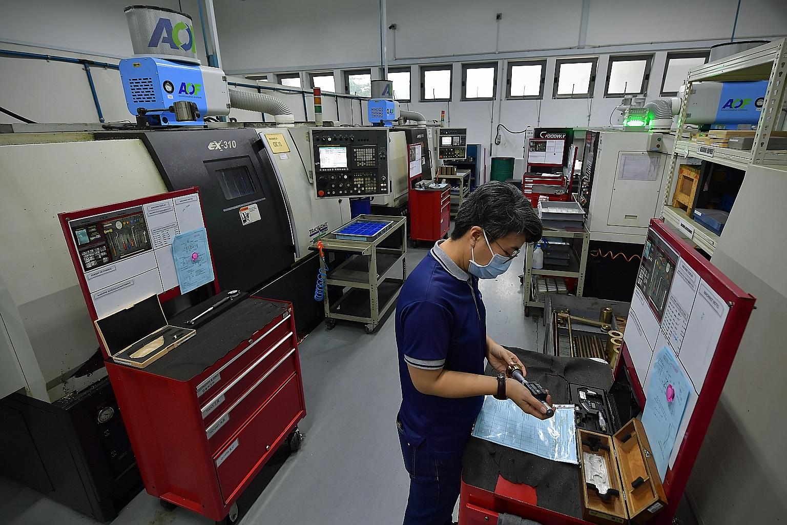 A computer numerical control machinist at Coway Engineering & Marketing inspecting a part produced by the company. The precision engineering firm has had to diversify beyond the aerospace and oil and gas sectors for business since the coronavirus pan