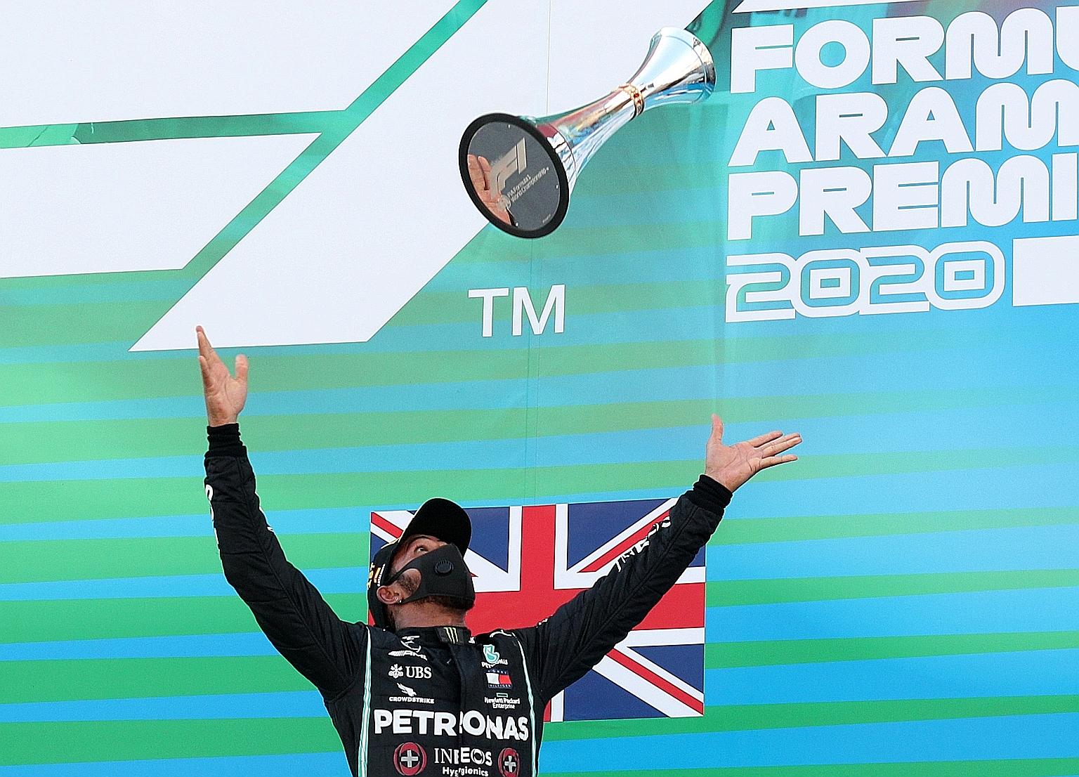 Mercedes' six-time world champion Lewis Hamilton tossing his Spanish Grand Prix trophy into the air on the podium after winning at the Circuit de Catalunya for the fourth year running and fifth time overall.