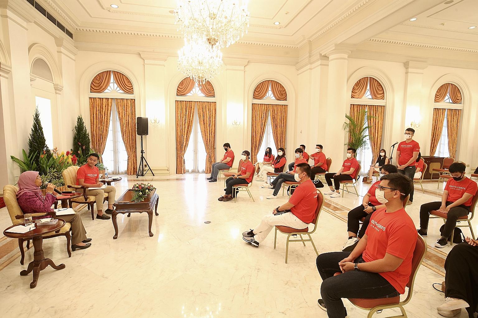 President Halimah Yacob, sitting next to host Muhammad Zaki Djuanda, 29, speaking to young leaders from Youth Corps Singapore yesterday at the Istana. The economy is in the process of restructuring and new markets and opportunities will open up, she
