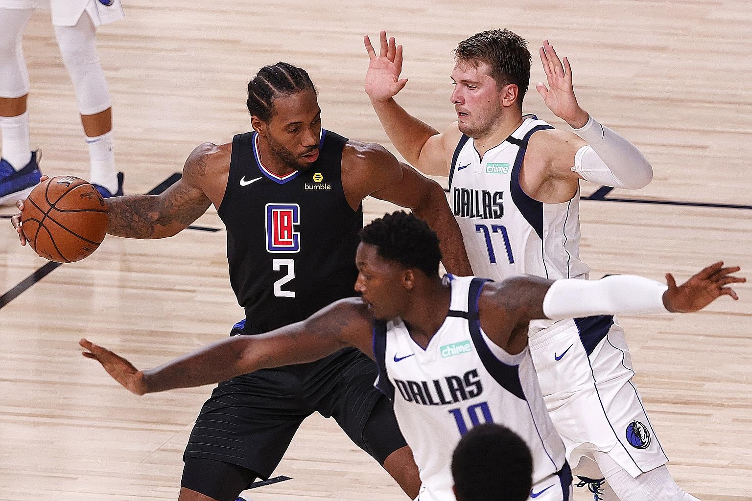 LA Clippers forward Kawhi Leonard being put under pressure by Dallas Mavericks' Luka Doncic (right) and Dorian Finney-Smith during Game 1 on Monday. He poured in 29 points in the Clippers' 118-110 victory over Dallas.