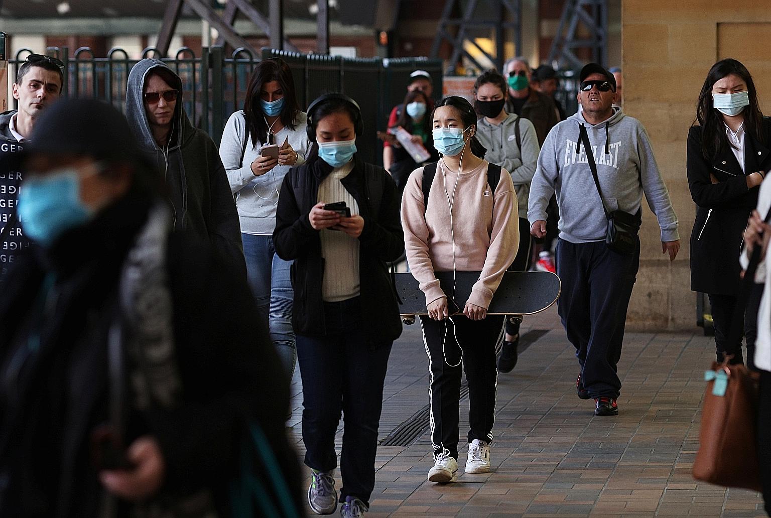 Commuters at Central Station in Sydney last week. The World Health Organisation said that many young people are unaware that they have been infected and are spreading the disease. One reason is that they may not see obvious symptoms that push them to