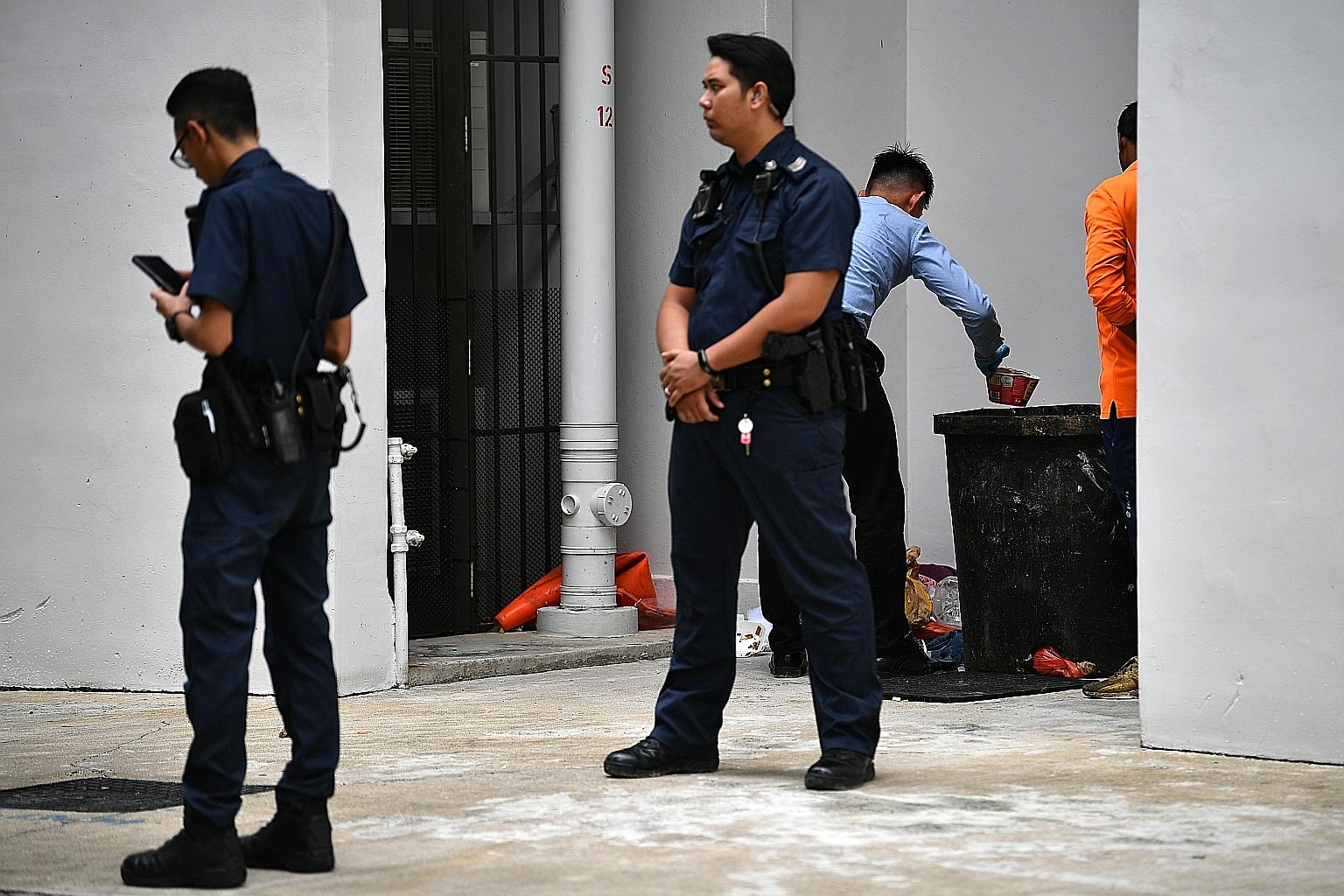 A Jan 7 photo showing the police checking the contents of the rubbish chute bin where the newborn baby was found alive by two town council cleaners. ST FILE PHOTO