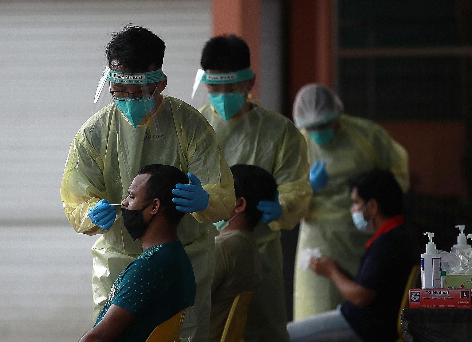 Medical staff conducting a routine swab test for migrant workers in Westlite Juniper dormitory on Tuesday. Recent cases of Covid-19 among foreign workers are being picked up now because the workers are reaching the end of their quarantine periods and