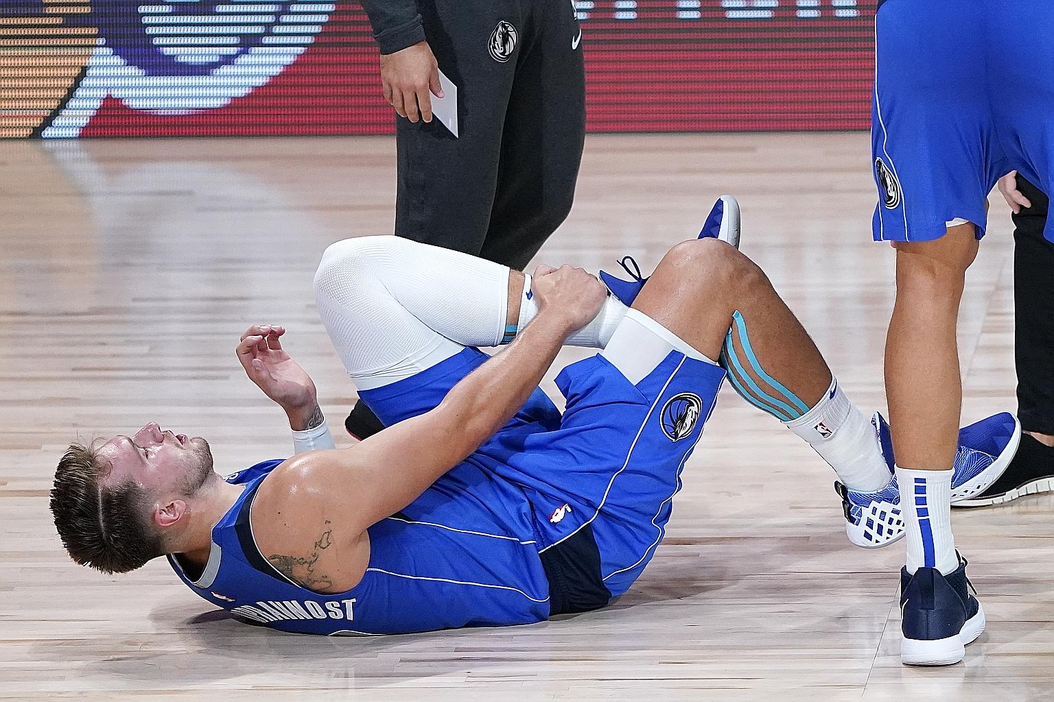 Dallas Mavericks' Luka Doncic grabbing his left leg after rolling his ankle against the Los Angeles Clippers on Friday. The Slovenian's participation in Game 4 of the series depends on an MRI exam he was scheduled to take yesterday.