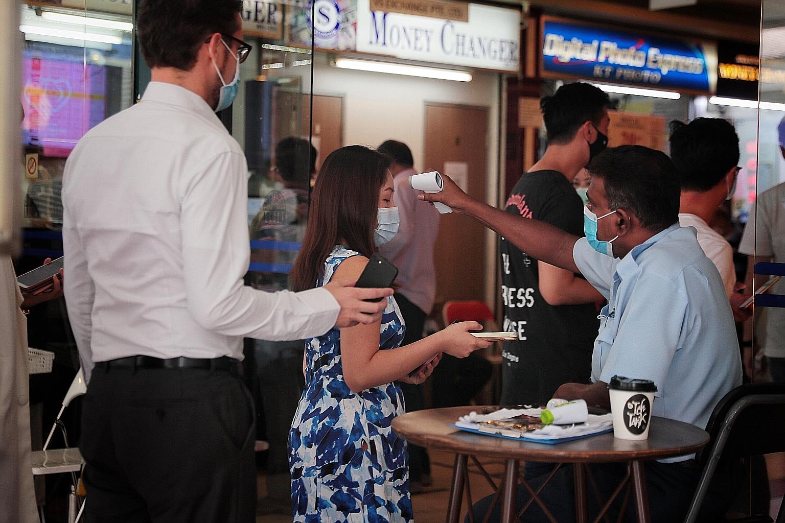 Office workers having their temperatures checked last Friday. A United Overseas Bank, Accenture and Dun & Bradstreet survey, which was conducted in the third quarter of last year before the coronavirus outbreak, as well as in May, showed that small b