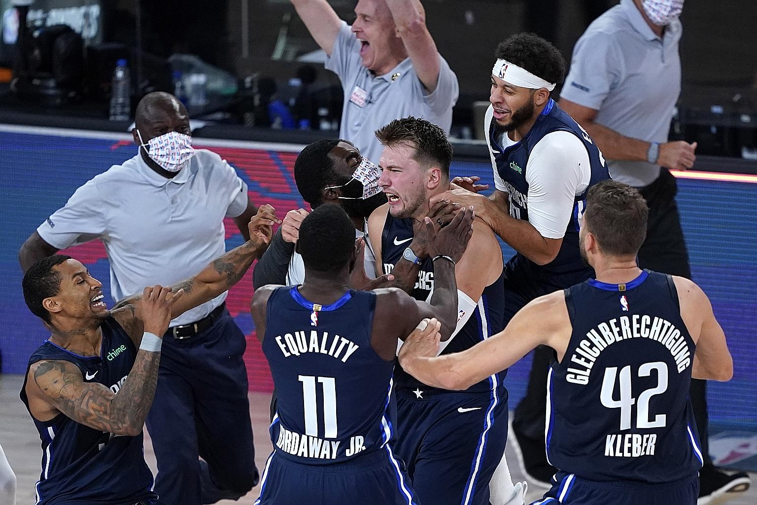 Dallas Mavericks star Luka Doncic is mobbed by his teammates after making the game-winning three-point basket in overtime. His step-back 28-footer is the second-longest buzzer-beating winner in NBA play-off history after Damian Lillard's 36-footer ag