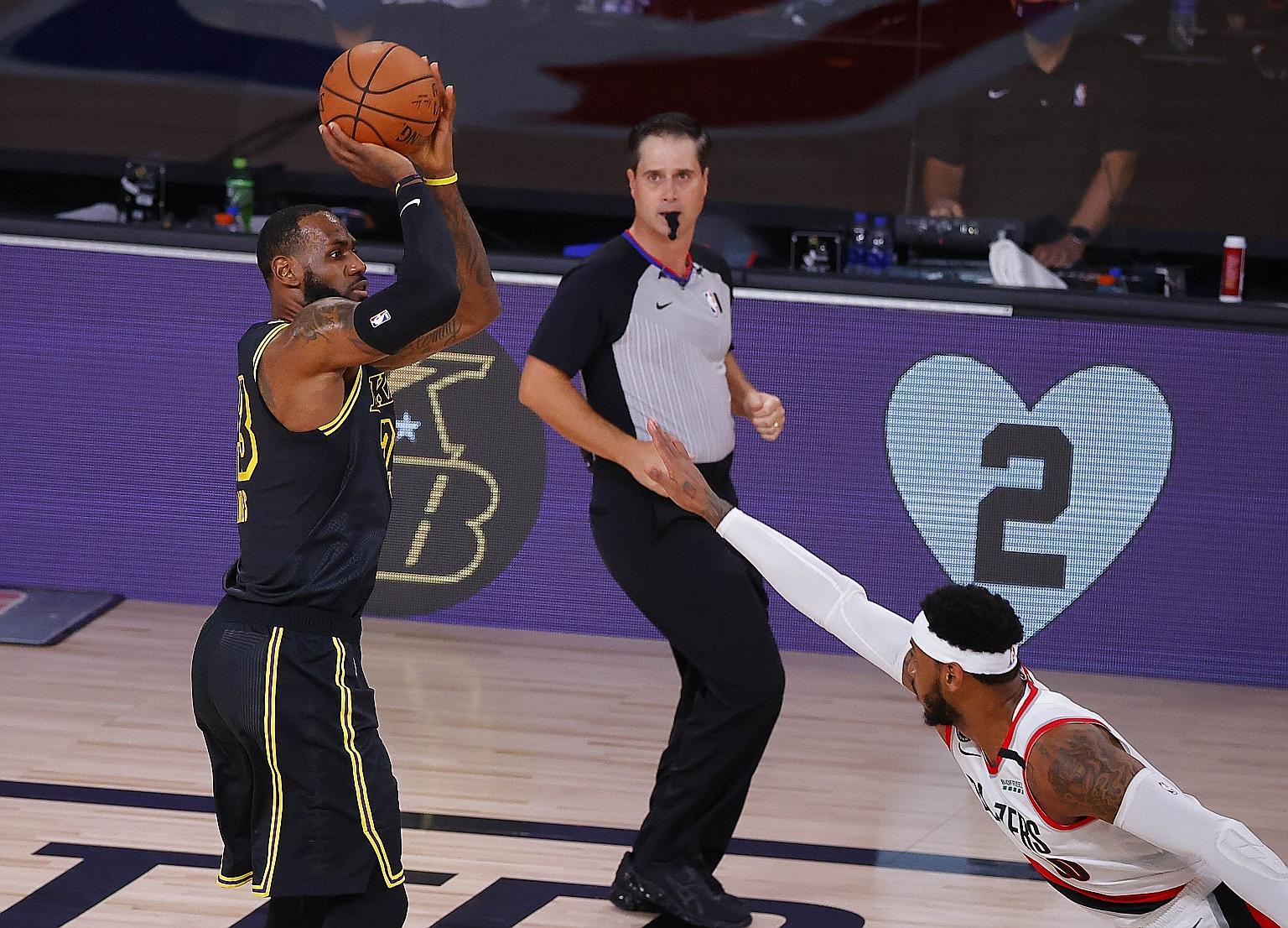 Lakers star forward LeBron James taking a shot as Carmelo Anthony of the Portland Trail Blazers attempts to block in Game 4 of their Western Conference first-round play-offs on Monday. James fired 30 points in Los Angeles' 135-115 victory to take a 3