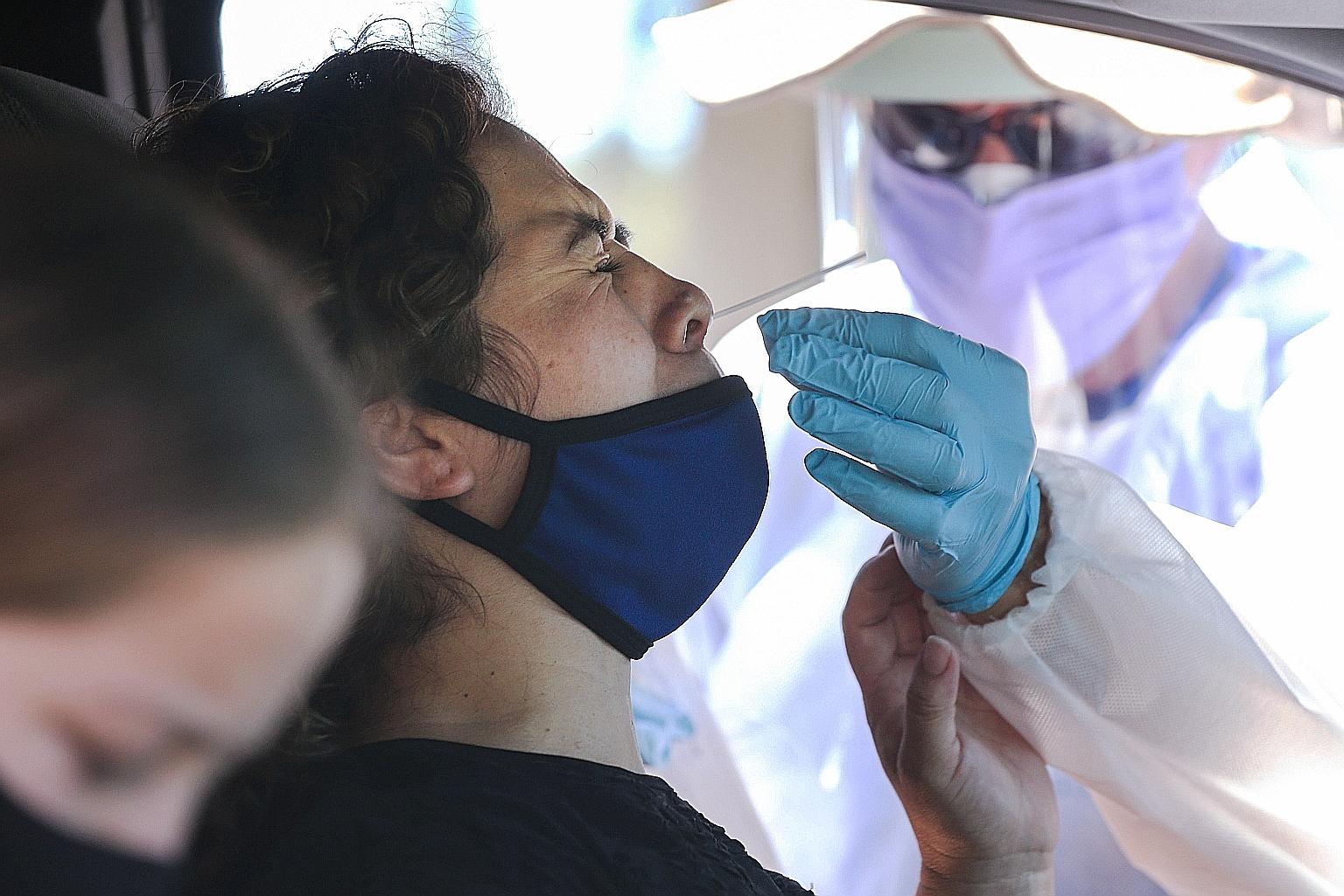 A motorist undergoing a Covid-19 nasal swab test at a drive-in testing centre in Los Angeles earlier this month.