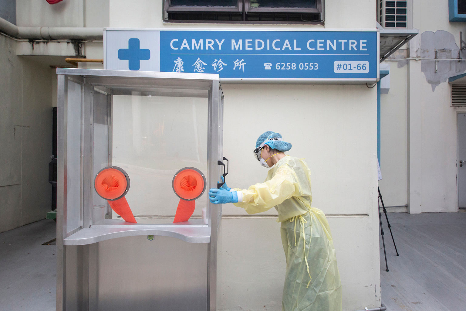 Above: Latex gloves are affixed to a panel separating the swabber from the patient, for doctors to insert their hands to collect patients' swab samples. Left: The swab booths, built using an aluminium frame and polycarbonate panels, are lightweight a