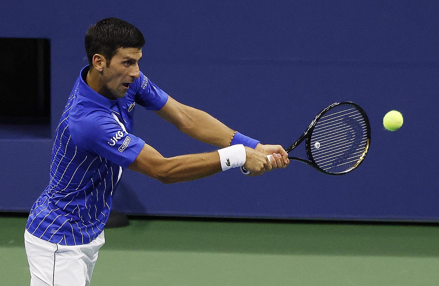 Novak Djokovic hitting a return to Damir Dzumhur of Bosnia and Herzegovina during their first-round match on Monday. The Serb won 6-1, 6-4, 6-1 in unusual strict conditions amid the coronavirus pandemic. PHOTO: EPA-EFE
