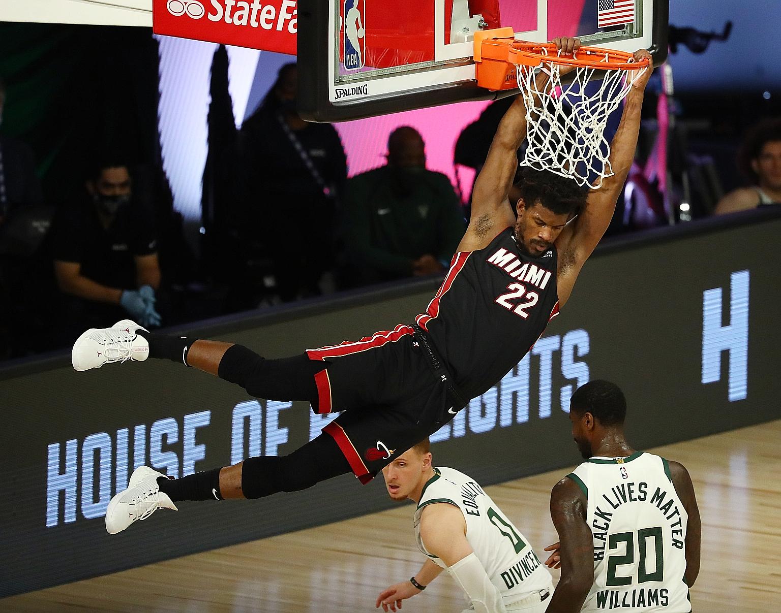 Miami Heat forward Jimmy Butler dunking the ball over Milwaukee Bucks guard Donte DiVincenzo (0) during the third quarter on Monday. The Heat won 115-104 to take a 1-0 lead in their Eastern Conference semi-final series. PHOTO: REUTERS