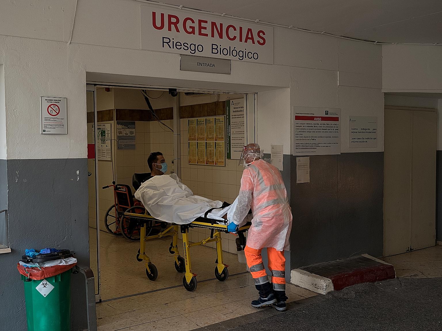 A suspected Covid-19 patient being wheeled into the emergency room of a hospital in Malaga, Spain, on Sunday. PHOTO: NYTIMES