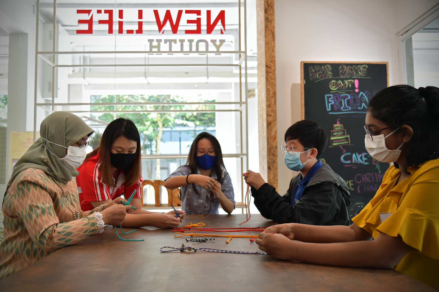 President Halimah Yacob during her visit to the New Life Youth Hub @ Fajar yesterday, where she met (from left) youth mentor Bong Kai Ning, 30, and New Life Community Services beneficiaries Ayumi Tan, 13, Tang Jia Xin, 14, and Vinathi Seenivasulu Nai