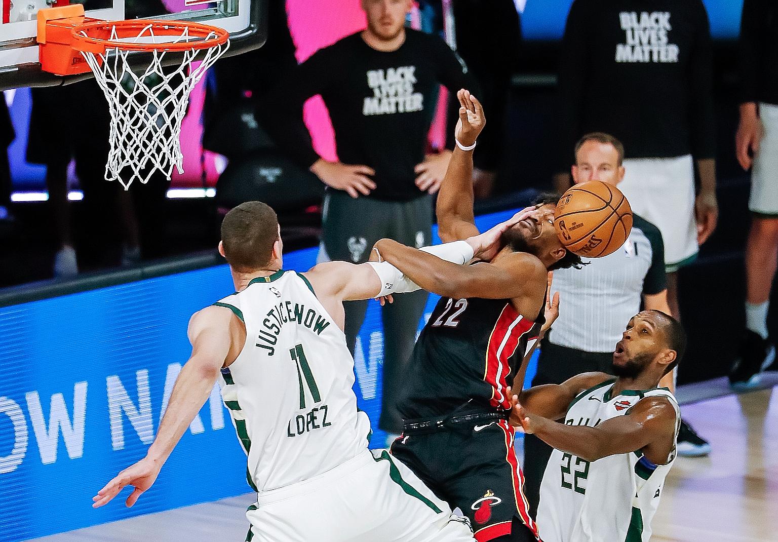 Milwaukee's Brook Lopez resorting to fouling Jimmy Butler to stop the Miami star from an easy bucket. Butler was more successful on other drives to the basket as the Heat dumped the Bucks out of the play-offs.