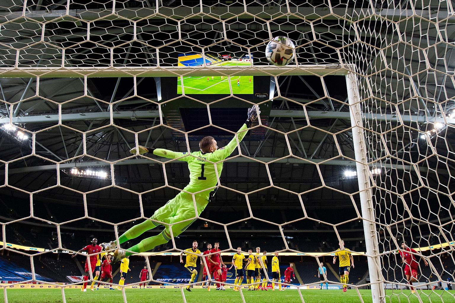 Sweden goalkeeper Robin Olsen grasping at thin air as Portugal forward Cristiano Ronaldo's strike finds the top corner of the goal. PHOTO: AGENCE FRANCE-PRESSE