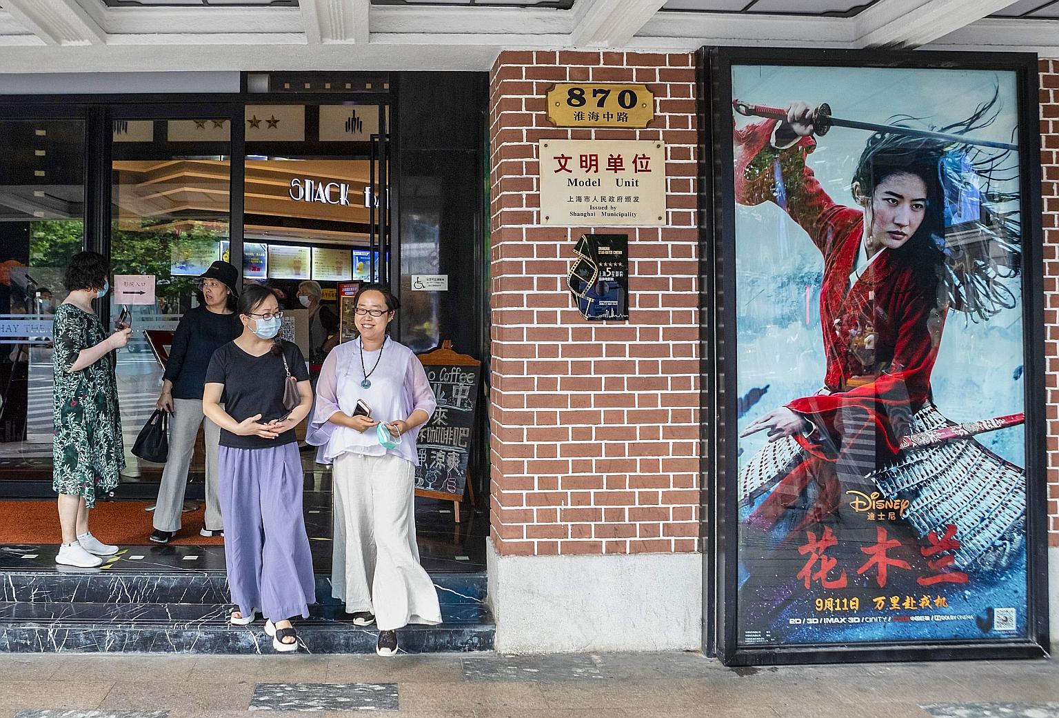 People exiting a cinema advertising the movie Mulan in Shanghai yesterday. In China, where the movie is set to open tomorrow, early viewers have also panned the film on movie review site Douban, rating it 4.7 points out of 10, accusing producers of O