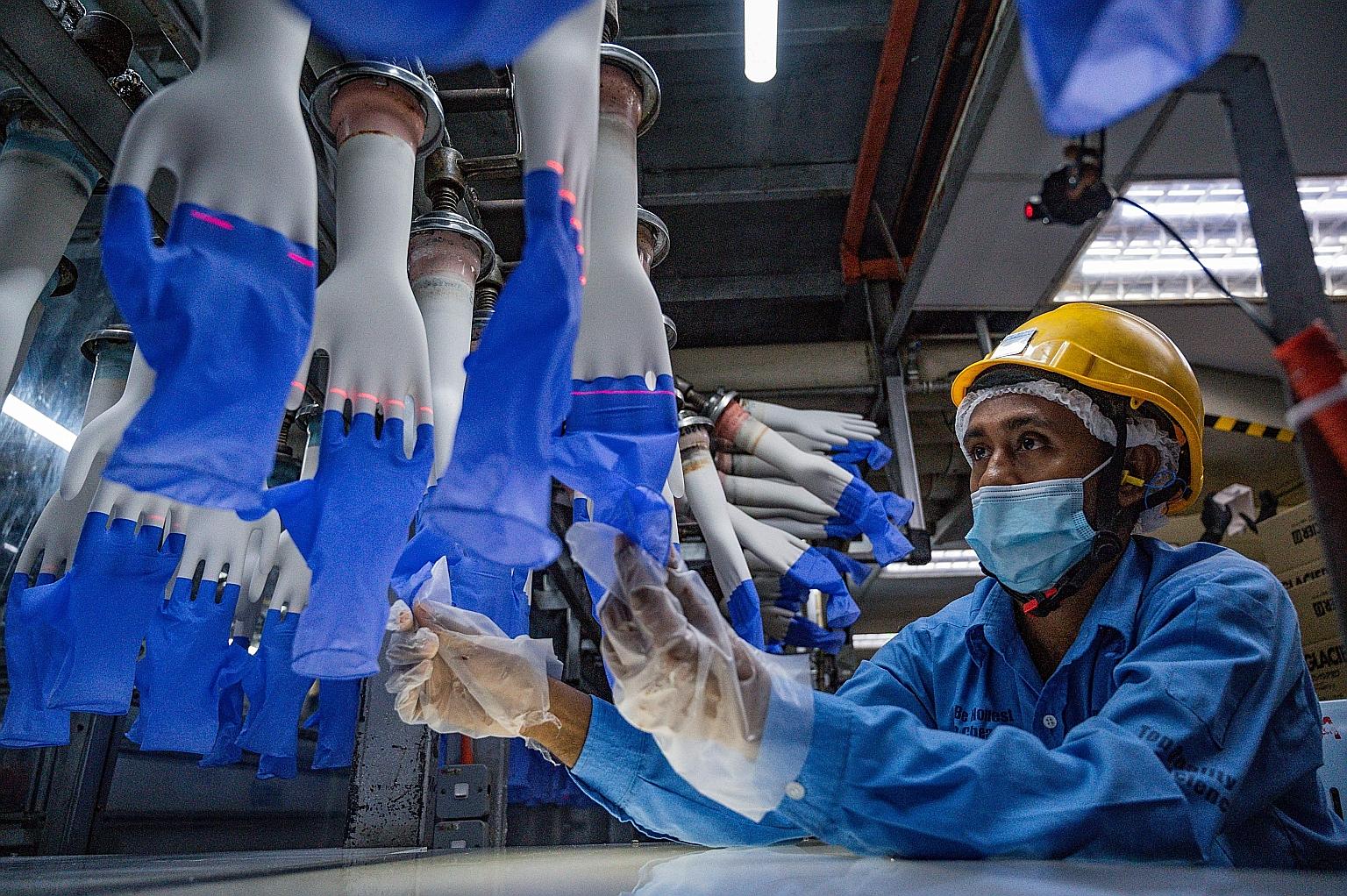 A worker inspecting disposable gloves at a Top Glove factory in Shah Alam, on the outskirts of Kuala Lumpur, last month. Malaysia's top three glove makers have added about RM100 billion (S$32.8 billion) in combined market value this year, with Top Gl