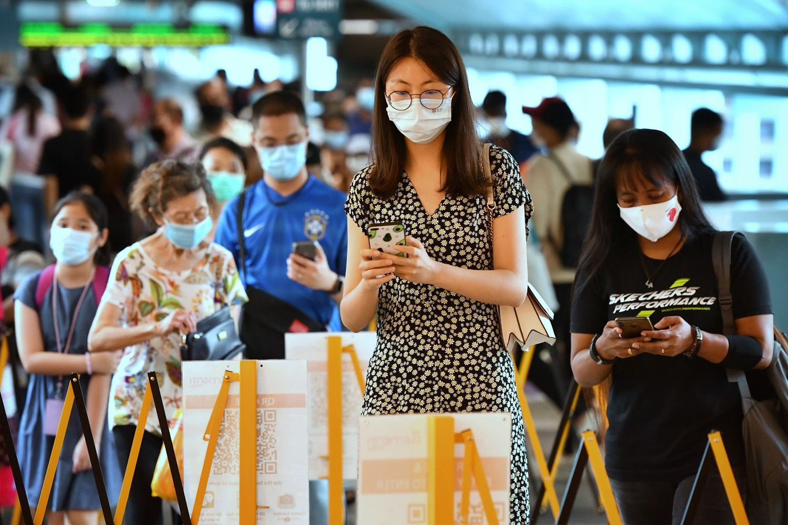 People using the national digital check-in system SafeEntry before entering Clementi Mall. The pilot initiative requiring people to check in using a TraceTogether token or mobile app will supplement SafeEntry check-in data with TraceTogether proximit