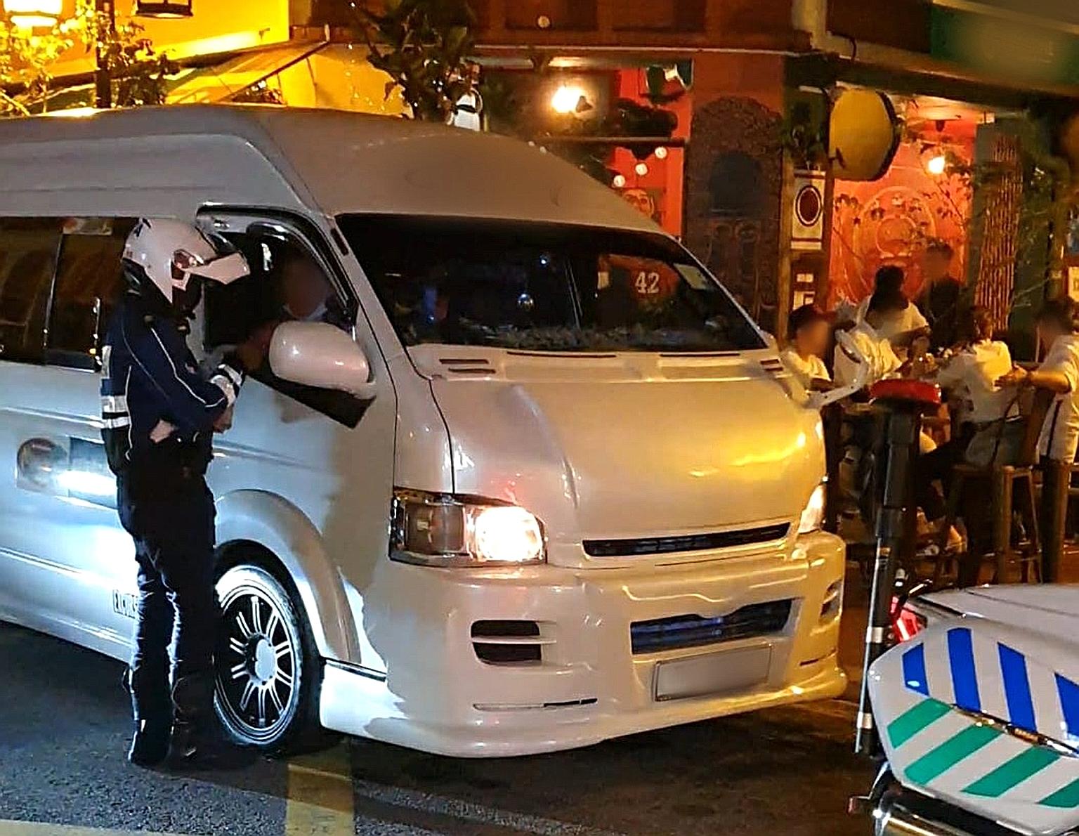 An LTA officer conducting an enforcement operation earlier this year. Apart from illegal modifications that threaten passenger safety, the buses could also "potentially thwart Singapore's efforts to limit Covid-19 transmission during this crucial per