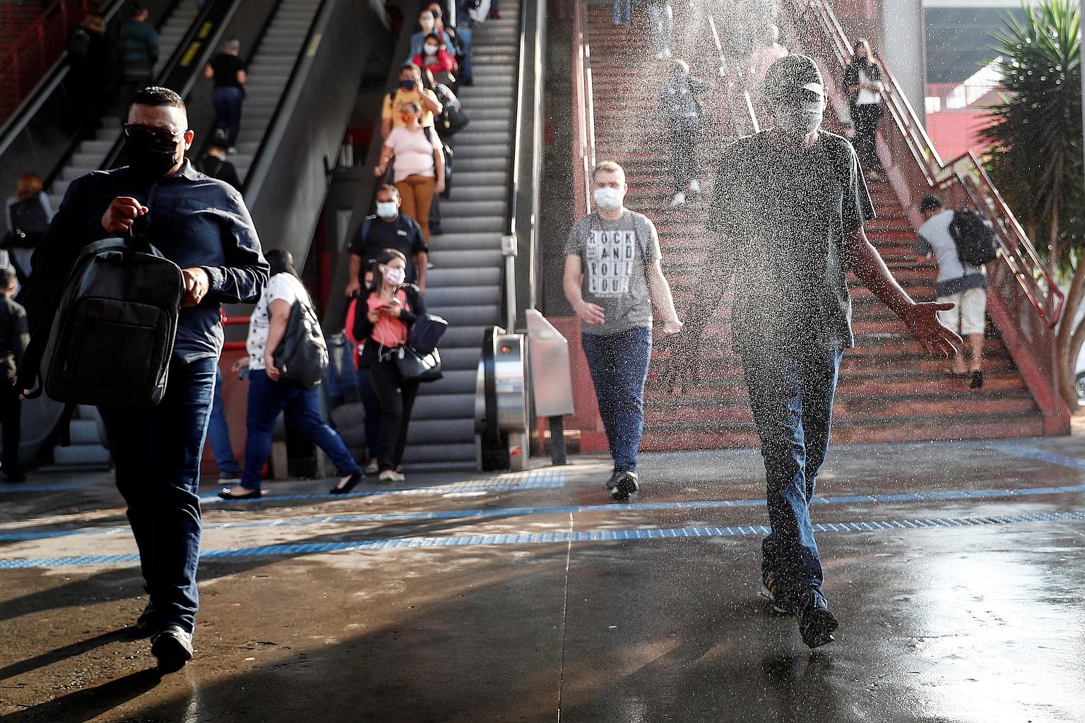 Commuters passing through a disinfection booth while leaving a subway station in Osasco, Sao Paulo, on Tuesday. Brazil has recorded a total of 4.1 million Covid-19 cases.