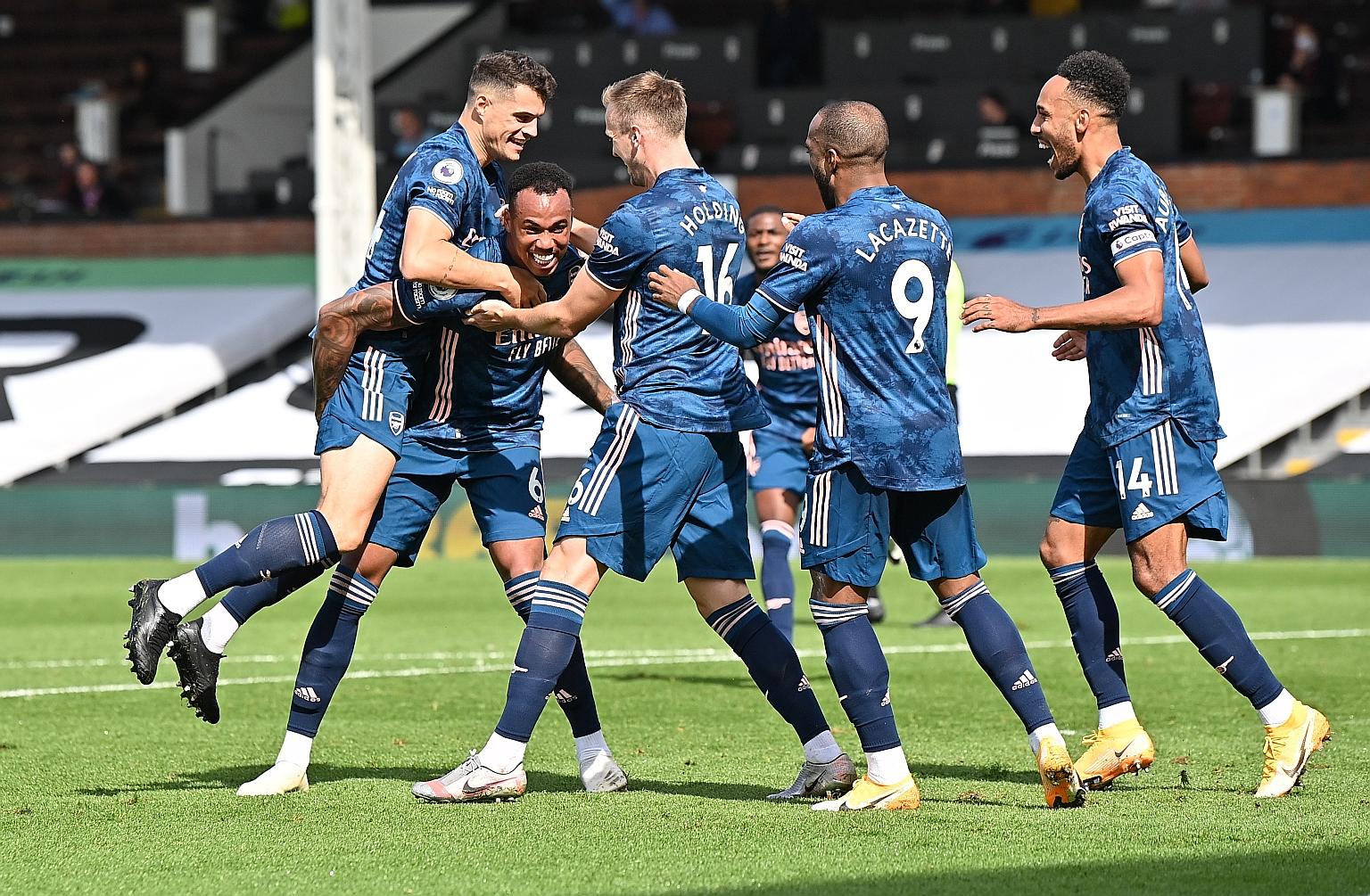 Arsenal players surrounding Brazilian defender Gabriel after he put them two up against Fulham yesterday. Captain Pierre-Emerick Aubameyang's strike rounded out the 3-0 EPL win at Craven Cottage.